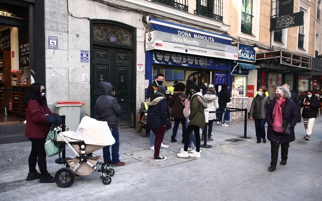 Varias personas hacen cola ante la administración de lotería Doña Manolita, en Madrid (España), a 5 de enero de 2021.