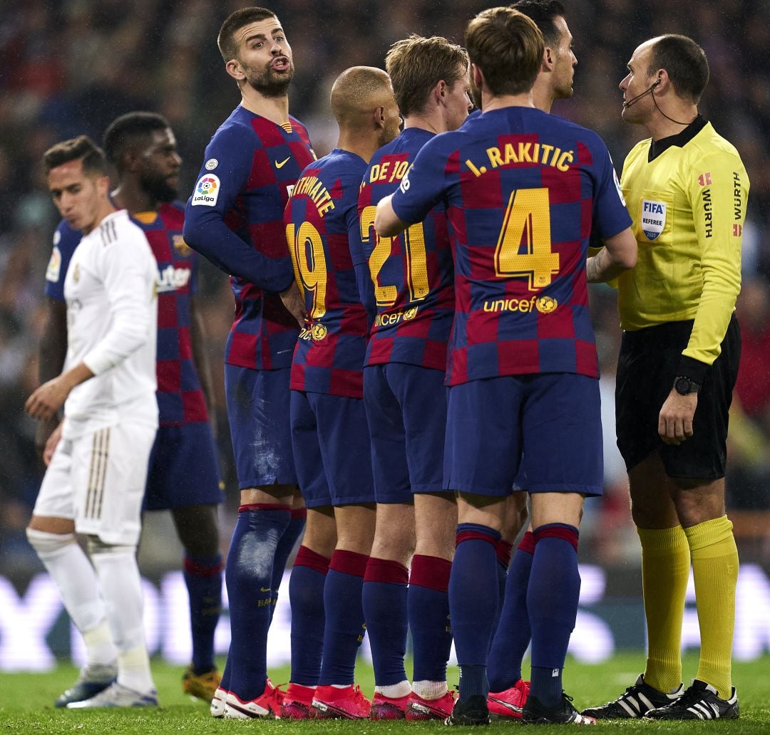 Los jugadores del Barça hablan con Mateu Lahoz durante el úlitmo Clásico.