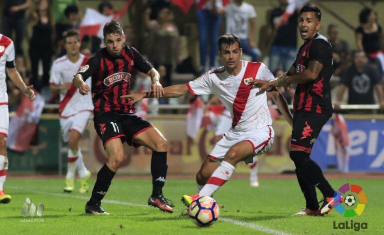 Fran Carbia i Jorge Díaz eviten la progressió d'un jugador del Rayo.