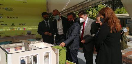 Responsables de la inauguración de Rehabilitaverde frente a la maqueta de la casa explicativa de la construcción sostenible