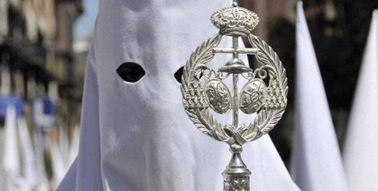 Un nazareno con vara de Los Negritos en la estación de penitencia del Jueves Santo