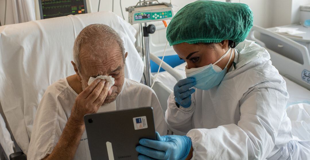 Un paciente del Hospital del Mar de Barcelona llora al conversar con sus familiares. 