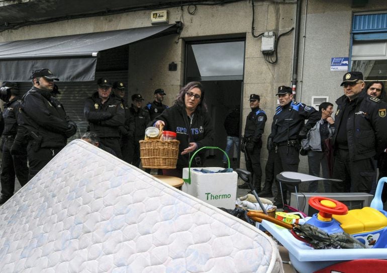 María sacando a la calle sus pertenencias antes de que no pueda entrar en la casa