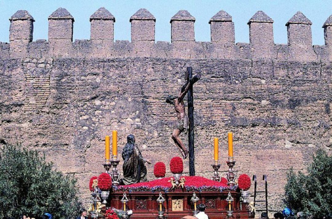 La Hermandad de La Hiniesta, en la imagen el primero de sus pasos discurriendo ante la Muralla de la Macarena, es la que más tiempo de paso por Carrera Oficial pierde, en total 6 minutos menos 