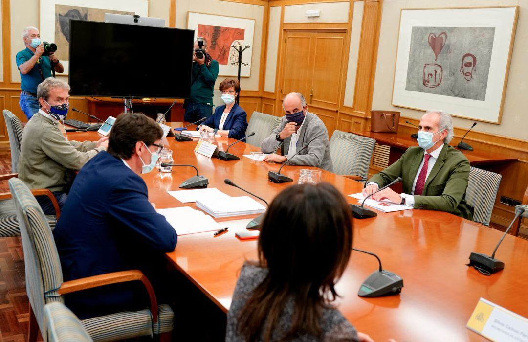 El ministro de Sanidad, Salvador Illa (2i); y el consejero de Sanidad de la Comunidad de Madrid, Enrique Ruiz Escudero (1d), junto con sus equipos.