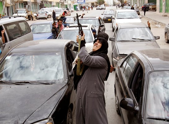 Una rebelde con un rifle AK-47 reacciona a la noticia de la retirada de las fuerzas del líder libio Muammar Gaddafi de Bengasi