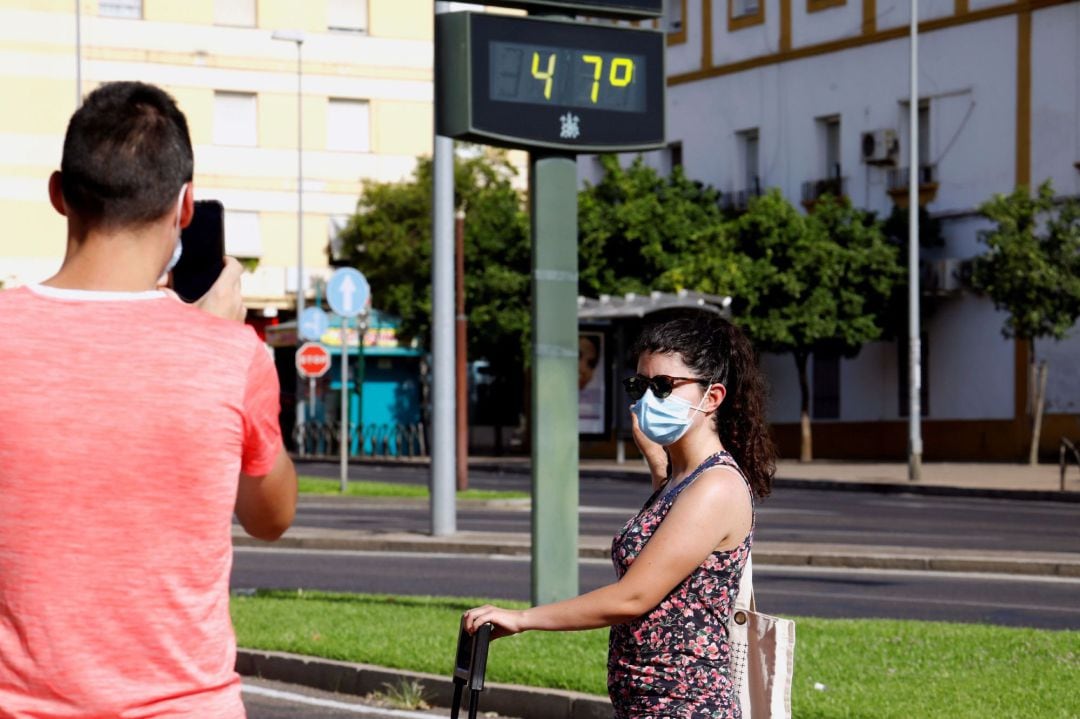 Unas personas se fotografían junto a un termómetro digital en Córdoba, donde la Aemet ha activado la alerta naranja como en otras provincias como Jaén y Sevilla. 