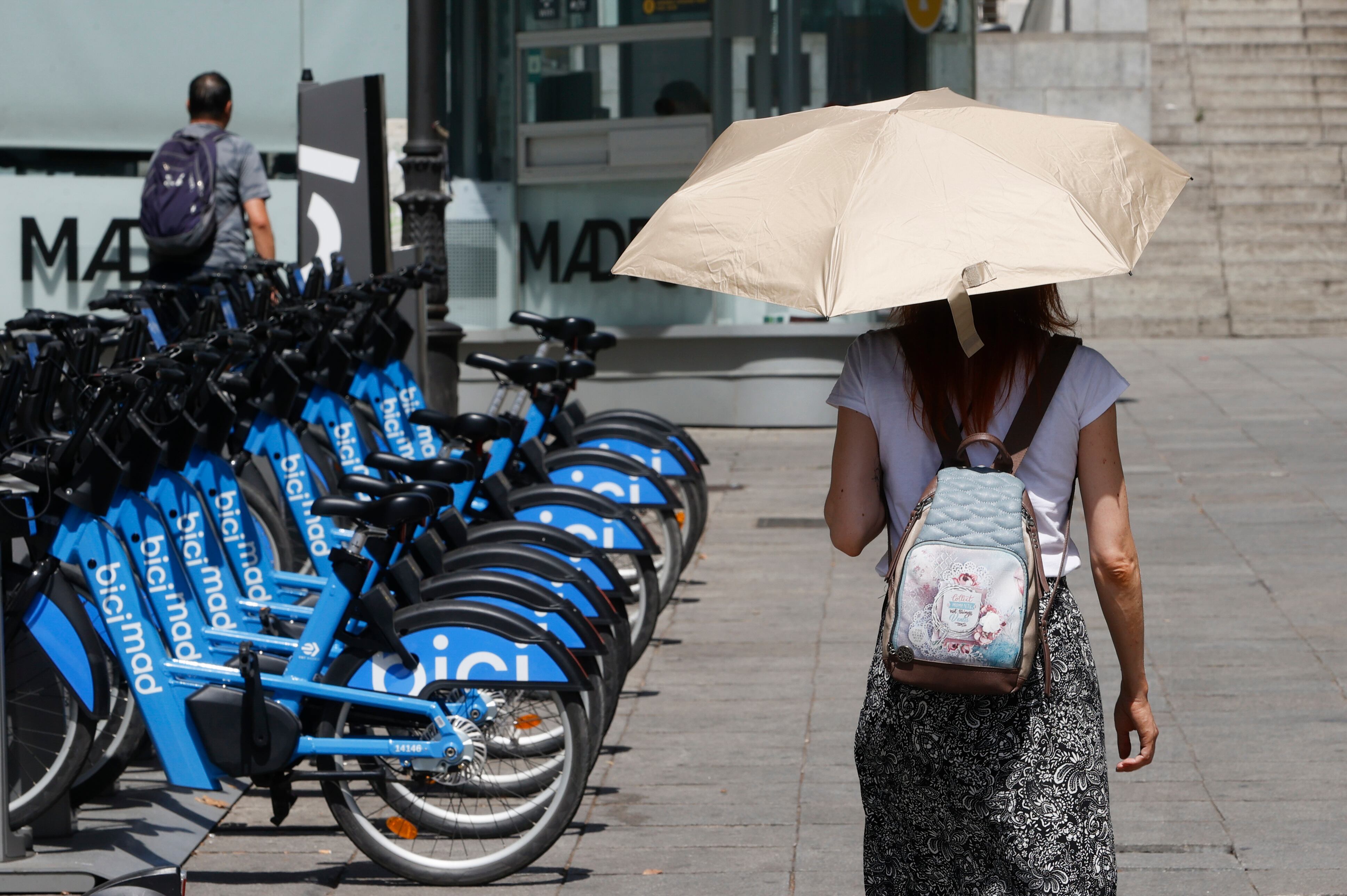 Una viandantes se protege del sol con un paraguas mientras camina por el centro de Madrid