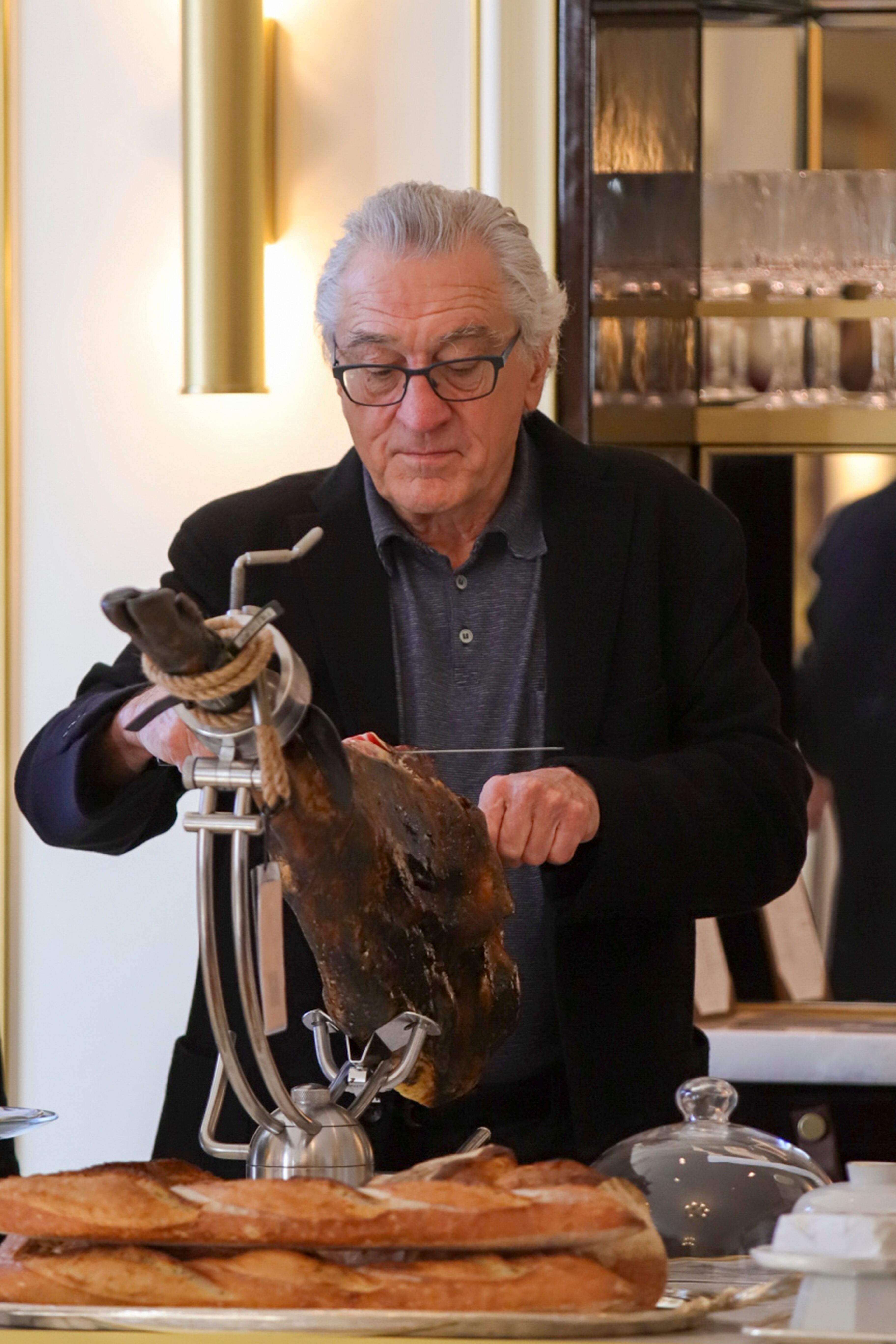 El actor estadounidense Robert De Niro posa cortando jamón en el hotel Mandarín Oriental Ritz de Madrid