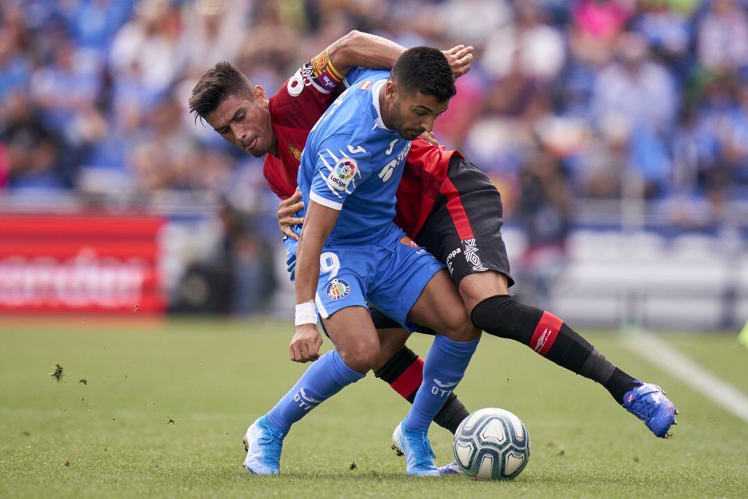 Ángel (Getafe CF) protege el balón ante Pedraza (RCD Mallorca) en el partido de la primera vuelta en el Coliseum 
