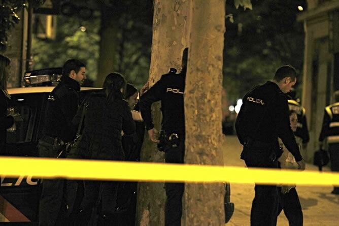 Miembros policiales asisten a una persona en el distrito de Puente de Vallecas, lugar en el que un joven de 16 años ha muerto esta noche tras ser tiroteado