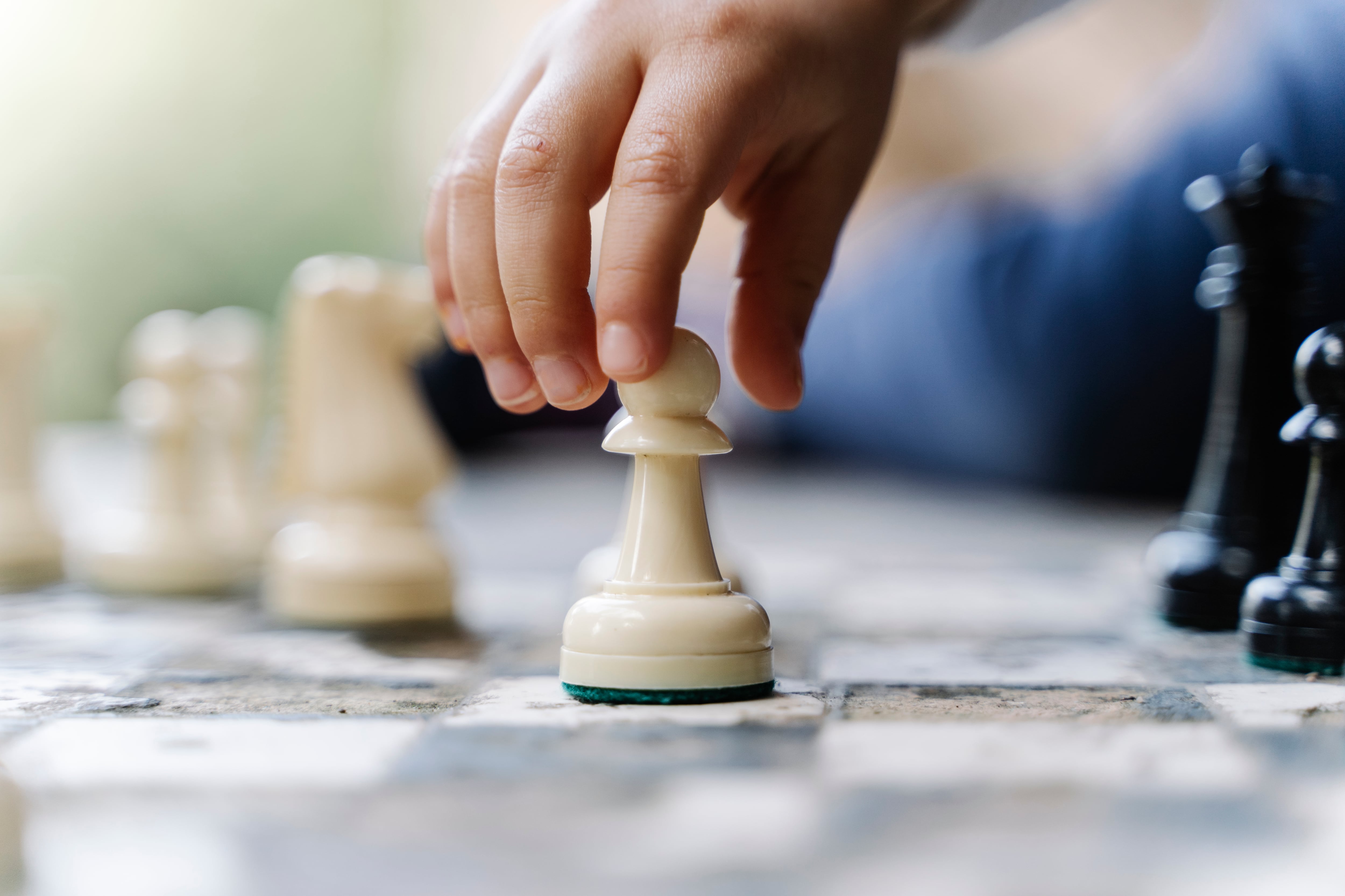 Child's hand moving the pieces of a chess board, close-up