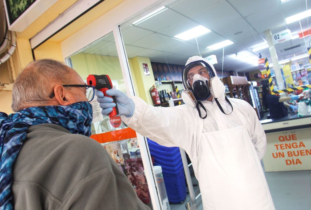 Un empleado de un supermercado de la zona de La Mata de Torrevieja toma la temperatura a sus clientes para prevenir que gente infectada acceda a la tienda 