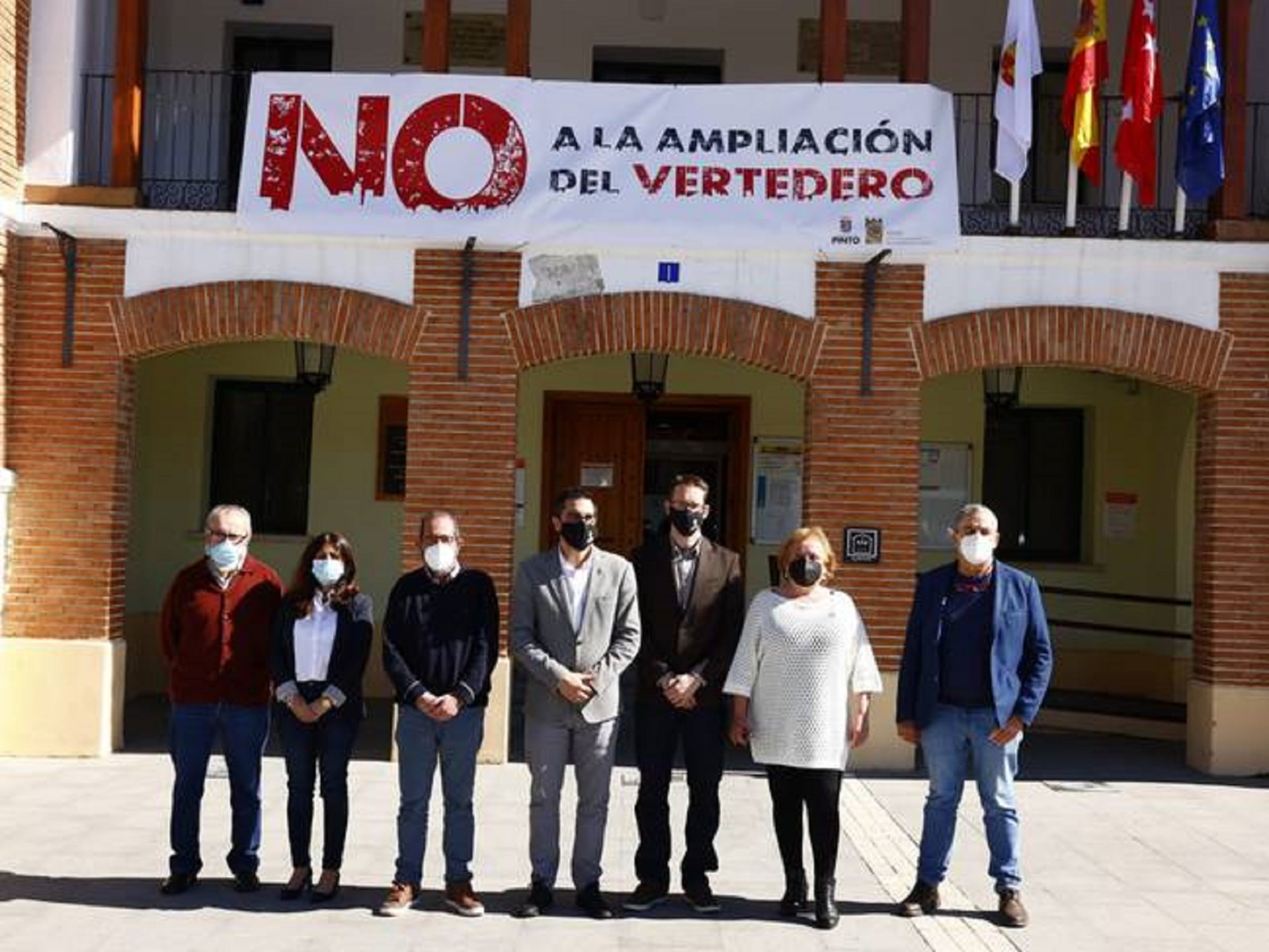 Alcalde de Pinto y miembros de su gobierno ante una pancarta contra la ampliación del vertedero situado en su término municipal.