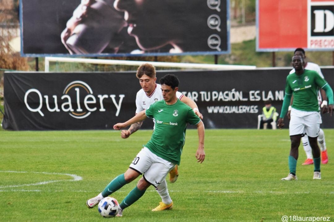 Hoyuela conduce el balón ante la presión del un rival