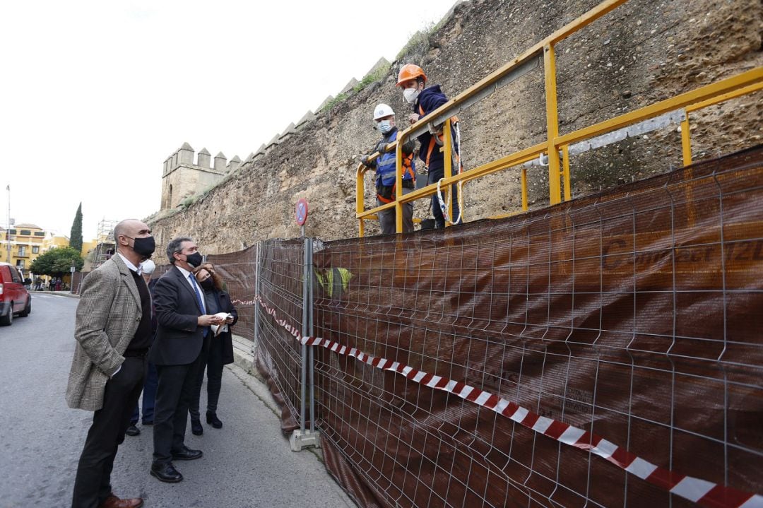 Juan Espadas, acompañado por el delegado municipal de Habitat Urbano, Antonio Muñoz, conversa con dos de los operarios que ya trabajan en la Muralla de La Macarena