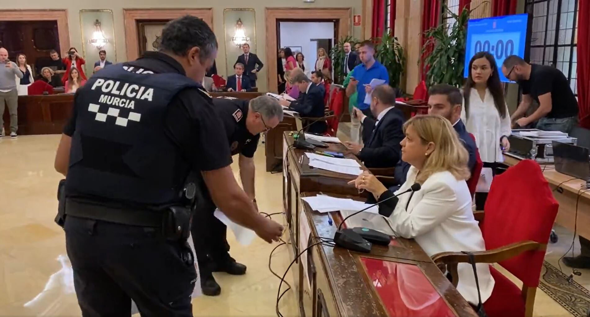 Dos agentes de la Policía Local de Murcia retiran los carteles