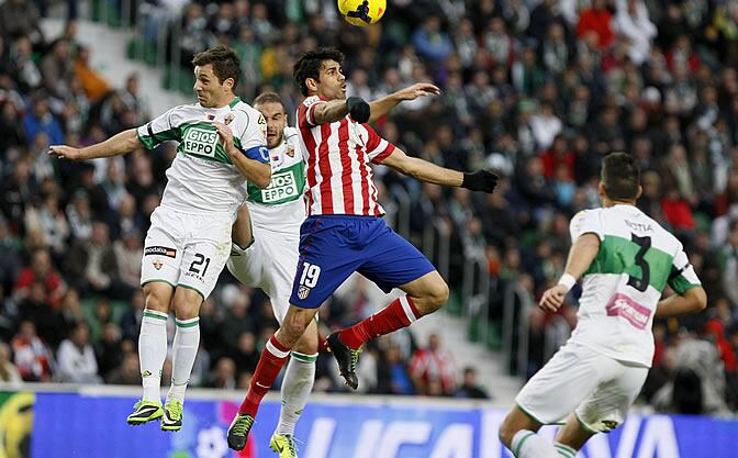 Diego Costa cabecea el balón ante el defensa del Elche Eduardo Albácar