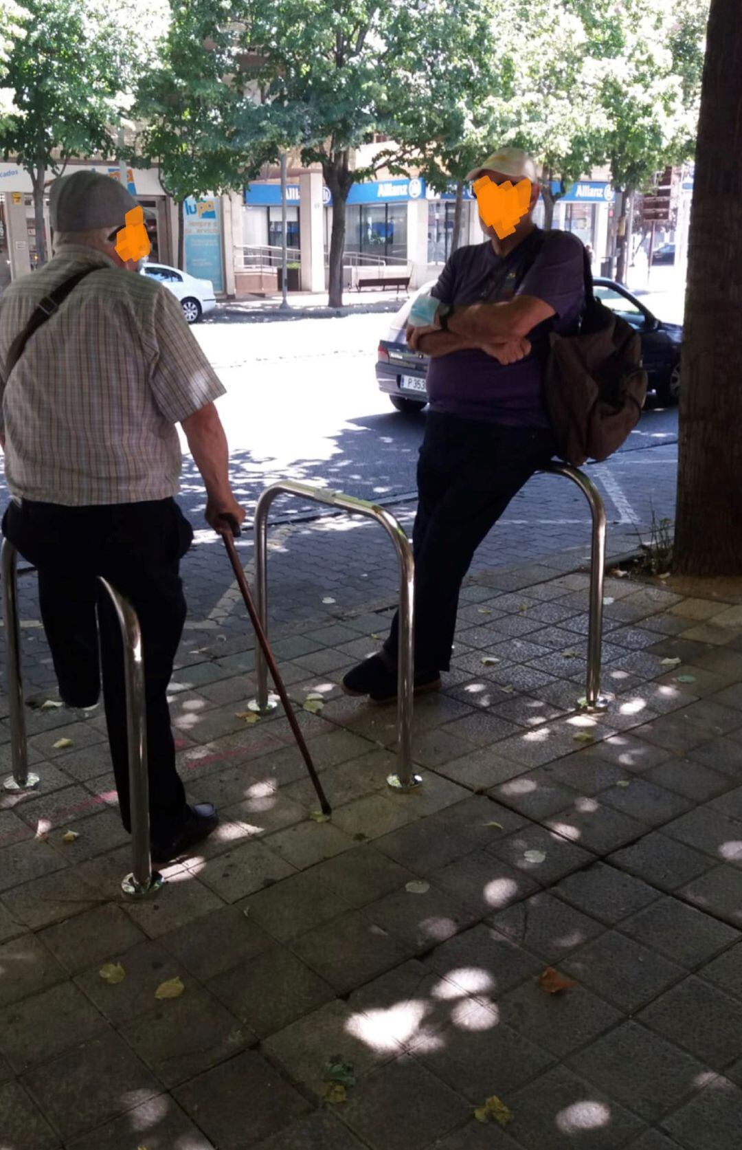 Usuarios del autobús utilizando los aparcabicis como asientos tras desaparecer la marquesina de autobús