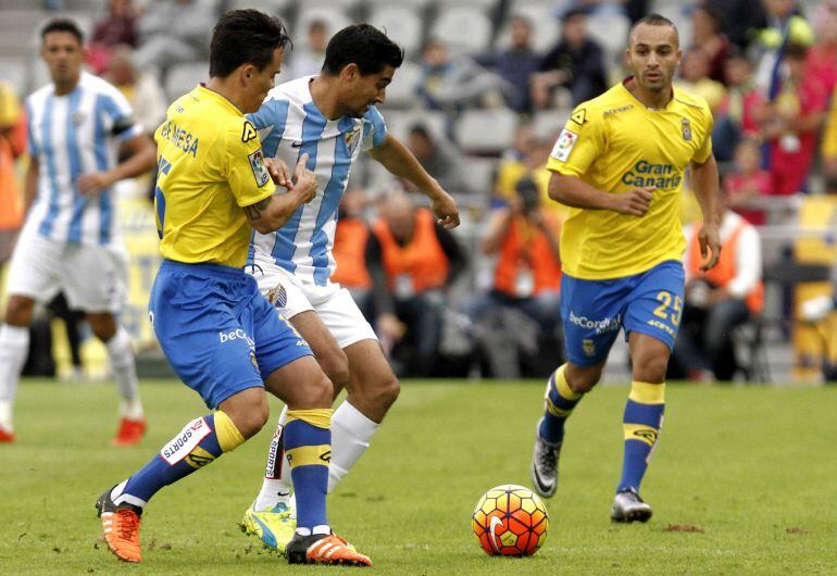 El defensa de la U.D. Deportiva Las Palmas, Roque Mesa, intenta impedir el avance del centrocampista uruguayo del Málaga, Gonzalo "Chory" Castro