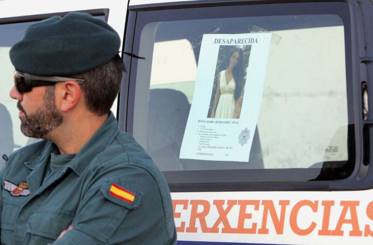 Un efectivo de la Guardia Civil junto al cartel de la joven Diana Quer, desaparecida en A Pobra do Caramiñal