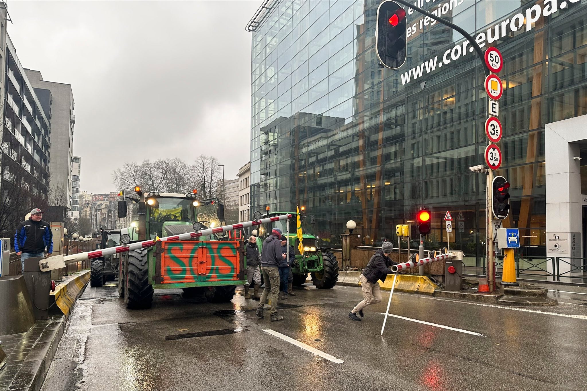 BRUSELAS, 26/02/2024.-  Agricultores forzando las vallas de entrada a uno de los túneles cerrados por la Policía para tratar de llegar lo más cerca posible de las instituciones europeas. Varias decenas de tractores entraron a primera hora de este lunes en el centro histórico de Bruselas, incluida la Grand Place, haciendo sonar sus bocinas, mientras que se espera que otros cientos que avanzan hacia la capital tomen el barrio europeo coincidiendo con la reunión de ministros europeos de Agricultura. EFE/Paula García-Ajofrín