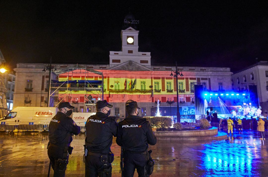 Tres policías nacionales observan el concierto de Nacho Cano en la Puerta del Sol, en Madrid (España), a 31 de diciembre de 2020