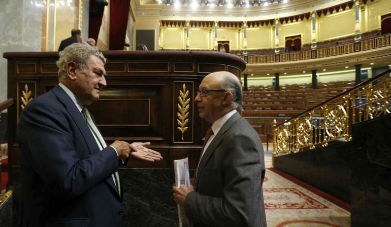  El ministro de Hacienda, Cristóbal Montoro (d), conversa con el presidente de la Cámara Baja, Jesús Posada (i), durante el pleno 