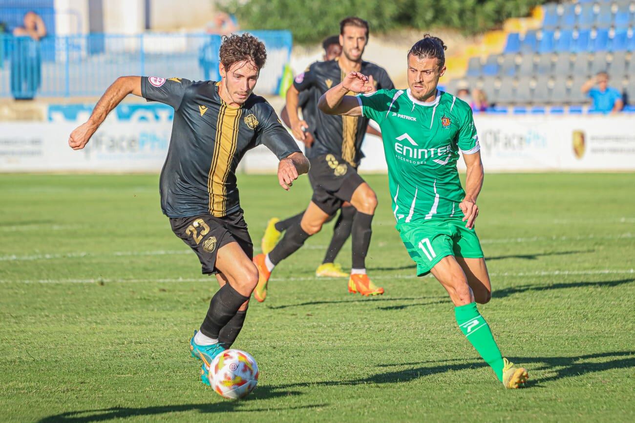 Aaron Piñán, jugador del Intercity, conduce el balón frente al Cornellà