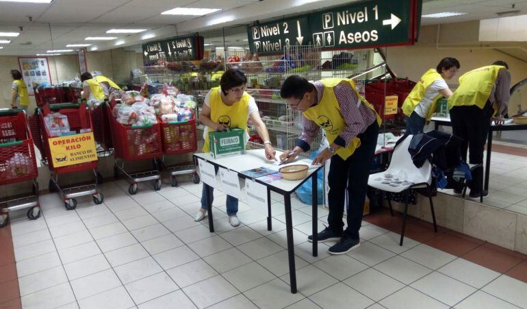 Dos voluntarios a las puertas del supermercado.