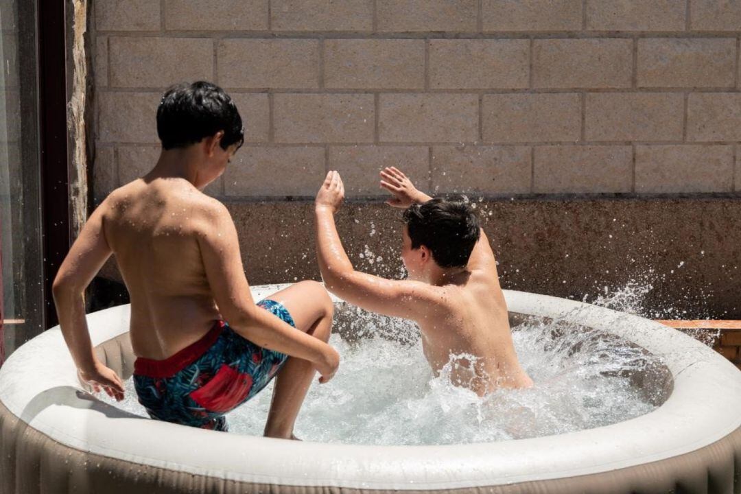 Dos niños juegan en una piscina hinchable