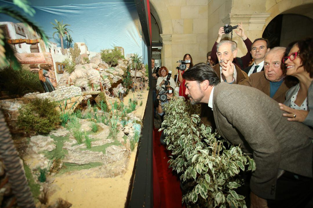 El alcalde observa el belén oficial que este año vuelve a los bajos del Palacio Consistorial