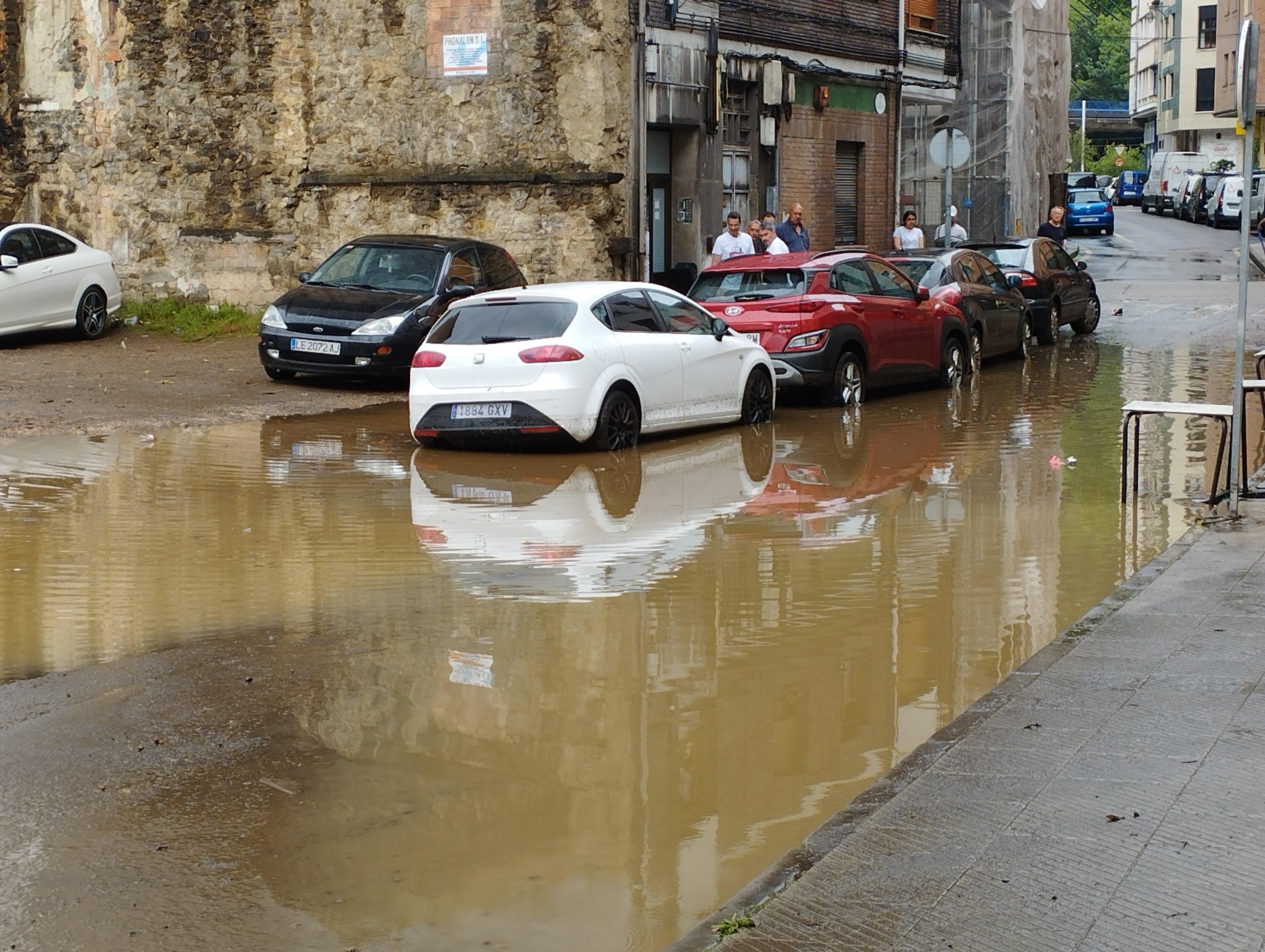 El agua acumulada obligó a cortar al tráfico varias calles en el barrio de La Nalona. En la imagen la calle Schultz, en Sama de Langreo.