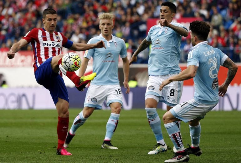 El centrocampista del Atlético de Madrid, Gabriel Fernández (i) con el balón ante los jugadores del Celta de Vigo, durante el partido de la 38º y última jornada de Liga de Primera División disputado en el estadio Vicente Calderón