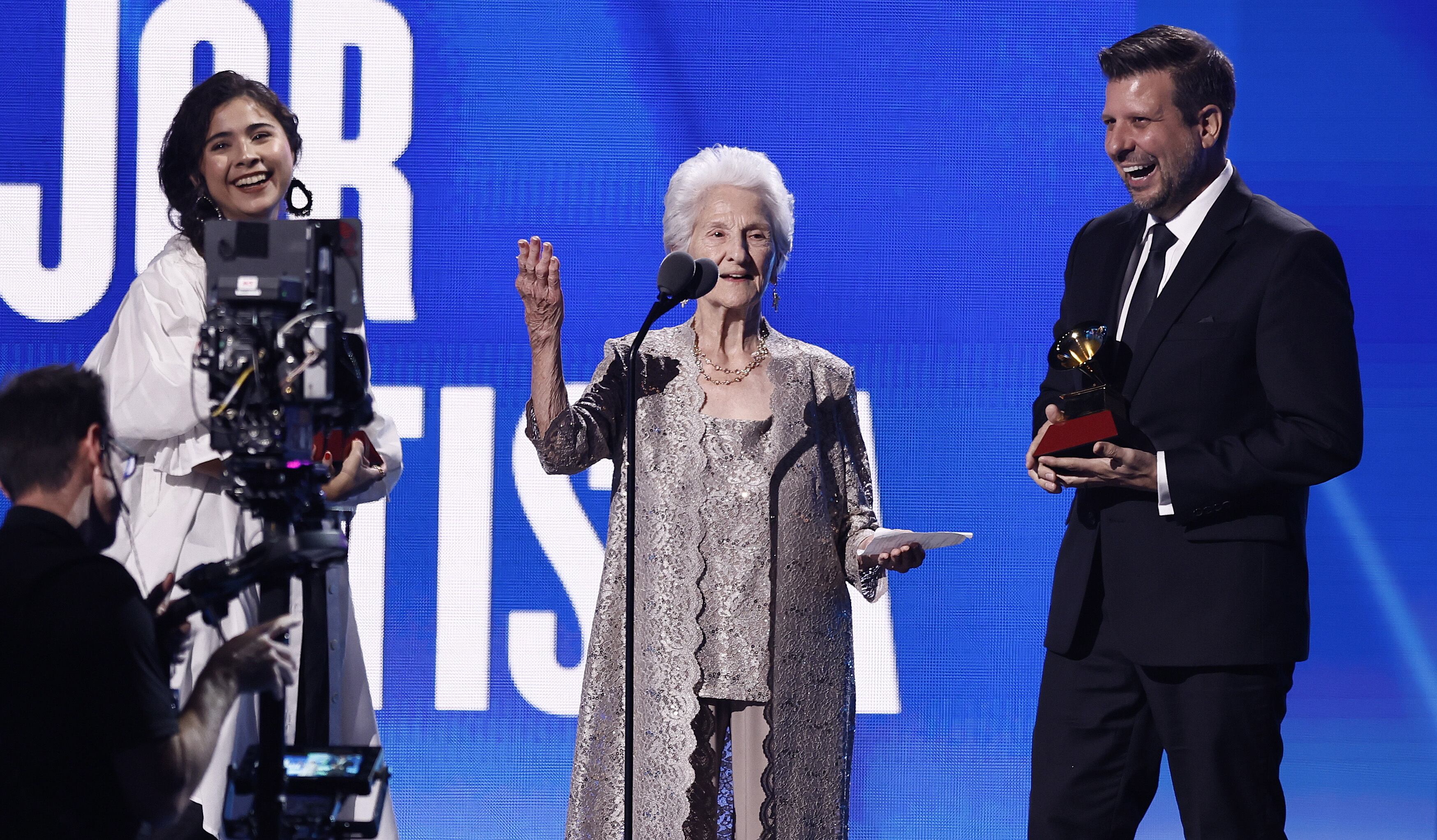 Ángela Álvarez recogiendo el premio junto a su nieto y con Silvana Estrada de fondo