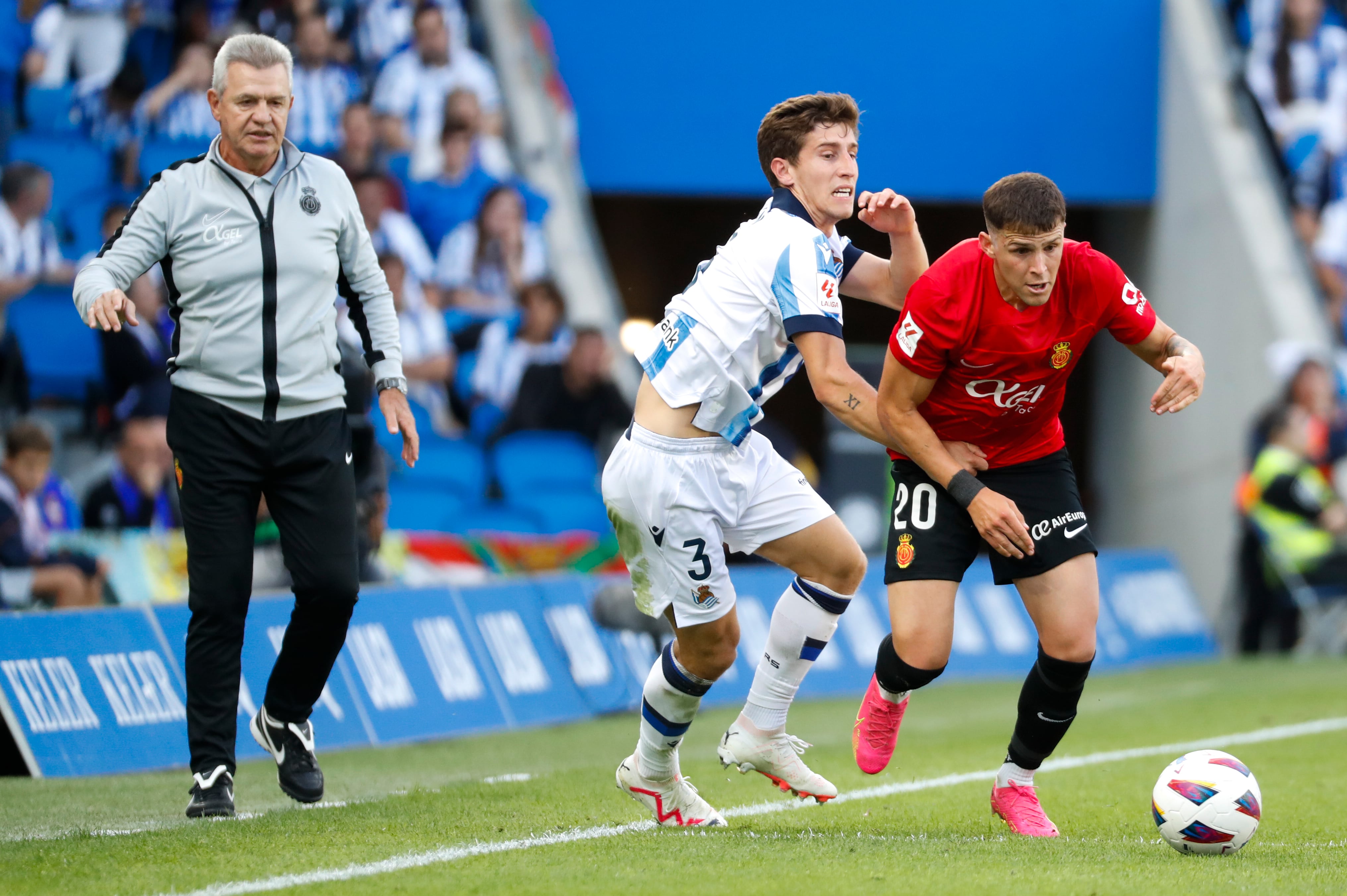 SAN SEBASTIÁN, 21/10/2023.- El defensa uruguayo del RCD Mallorca Giovanni Alessandro González (d) disputa una posesión ante Aihen Muñoz (c) defensa de la Real Sociedad durante el partido de la jornada de Liga de Primera División disputado en el estadio de Anoeta, en San Sebastián. EFE/Juan Herrero
