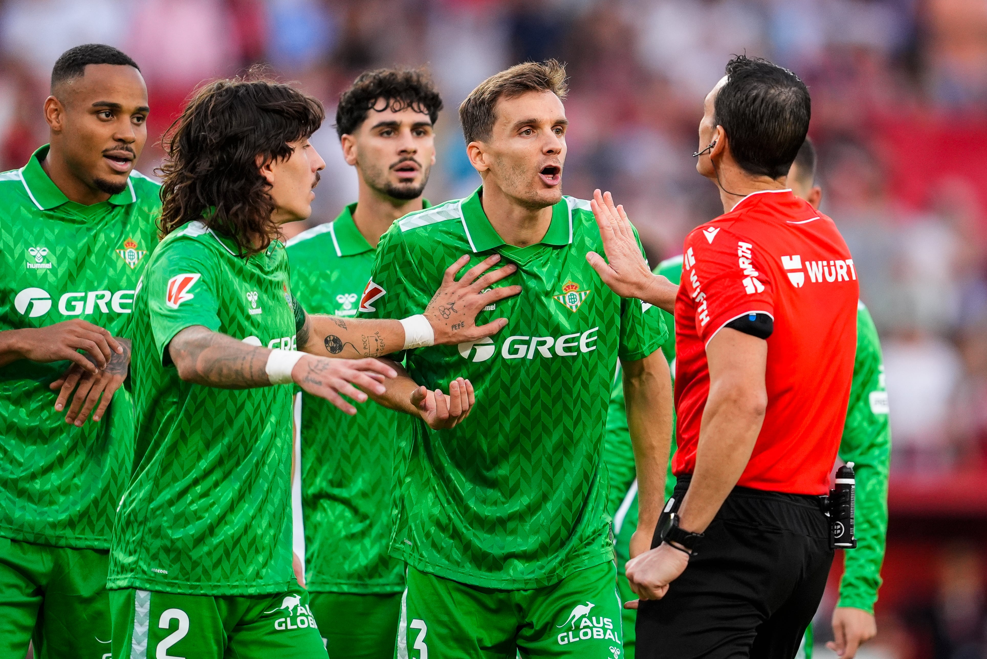 Diego Llorente y los jugadores del Betis protestan el penalti durante el derbi