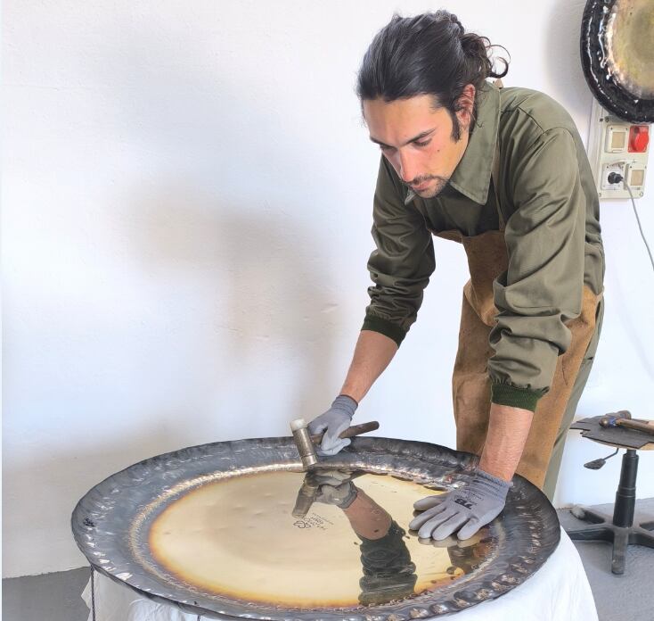 Adrián Lenhardy elaborando uno de sus gongs artesanales.
