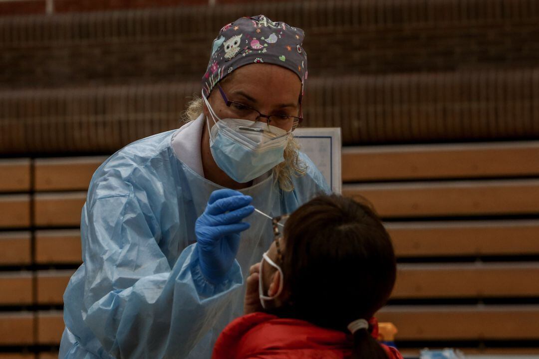 Una sanitaria realiza un test de antígenos para detección del coronavirus a una vecina de la zona básica de salud de San Juan de la Cruz en el polideportivo municipal El Torreón, en Pozuelo de Alarcón