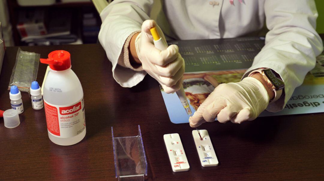 Una farmacéutica de la Farmacia Portal Martínez Soto introduce en una placa la muestra de sangre que ha tomado para realizar un test de cribado del coronavirus en Barbadás.