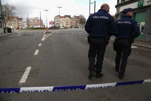 BRUSSELS, BELGIUM - MARCH 25:  Police officers guard a cordoned-off area during a raid off of Place General Meiser in the Schaarbeek (Schaerbeek in French) district on March 25, 2016, in Brussels, Belgium. Explosions from police flash grenades and bomb di