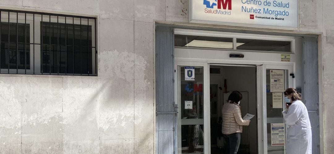 Una mujer conversa con una trabajadora sanitaria en la puerta del Centro de Salud Núñez Morgado