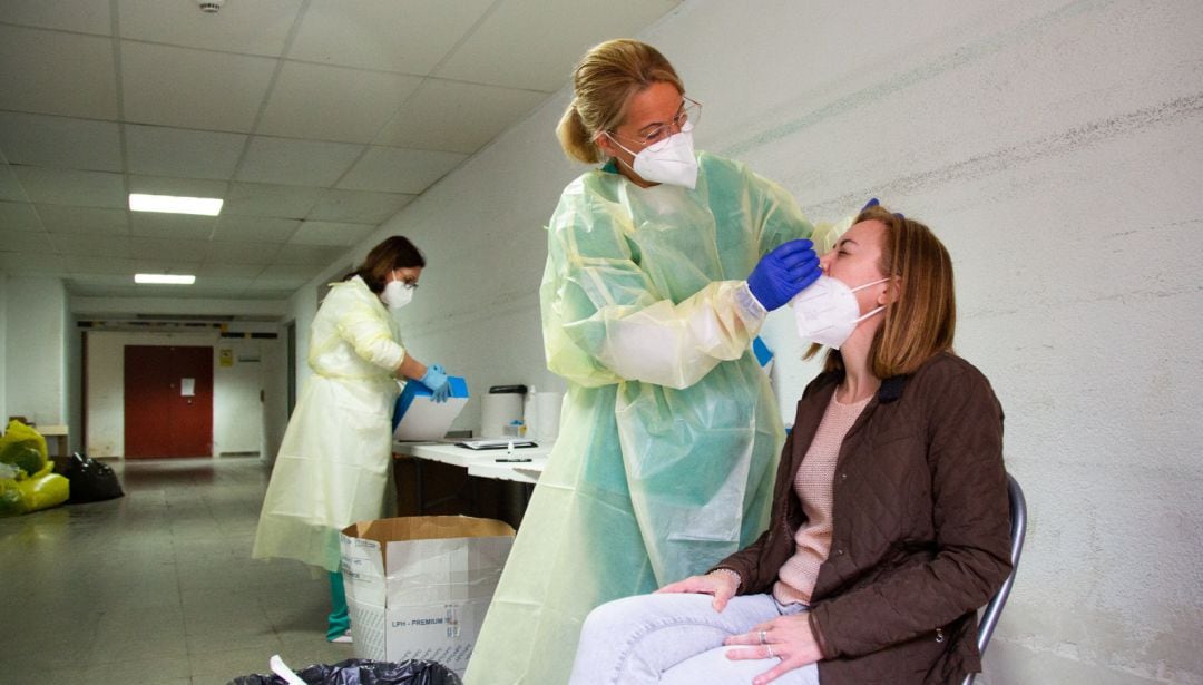 Archivo - Una sanitaria realiza un test de antígenos o una PCR a una mujer.