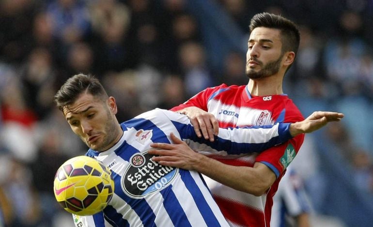 El centrocampista del Deportivo de La Coruña, Lucas Pérez (i), protege la pelota ante Fran Rico (d), del Granada.