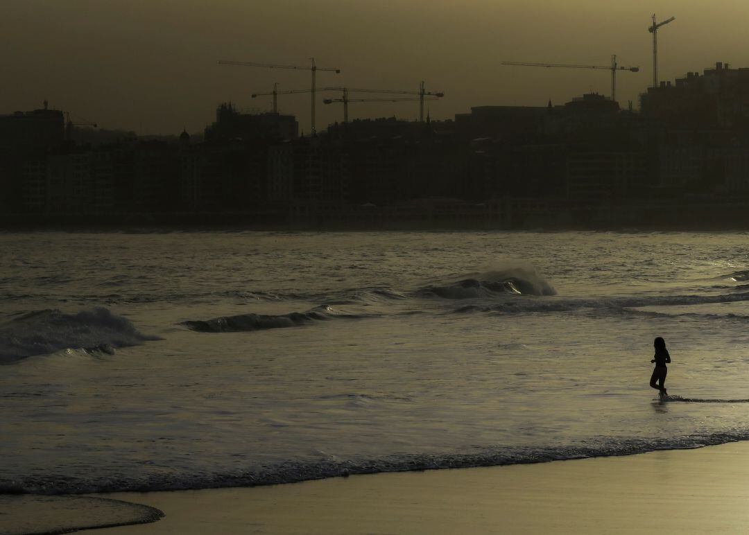 Una mujer se baña en la playa de Ondarreta, en San Sebastián. 