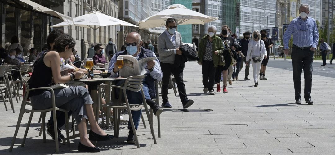 Un grupo de personas charla en la terraza de un local de hostelería de A Coruña