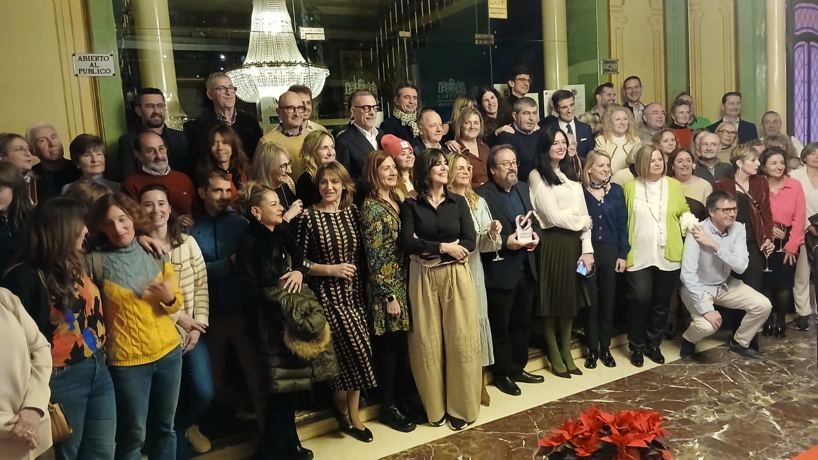 Comerciantes, autoridades, homenajeado y miembros de ASAFA, tras el brindis navideño, en las escaleras del Casino