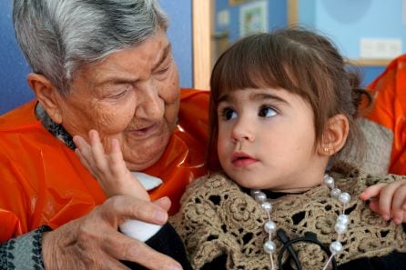 Carmen, junto a una niña de la escuela infantil.