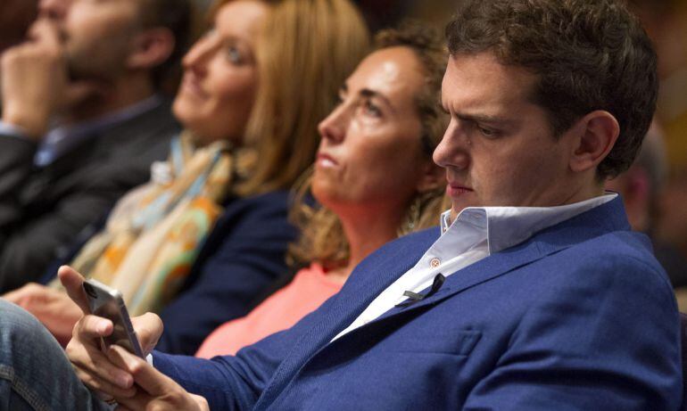 GRA135 VALENCIA, 10/05/2015.- El presidente de Ciudadanos, Albert Rivera, consulta su teléfono móvil durante el mitin celebrado este mediodía en Valencia. A su lado, la candidata del partido a la Presidencia de la Generalitat, Carolina Punset. EFE/Manuel 