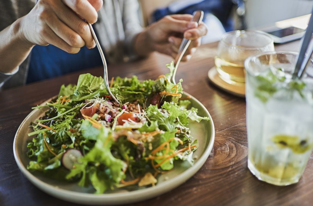 Foto de archivo de una persona comiendo ensalada. 